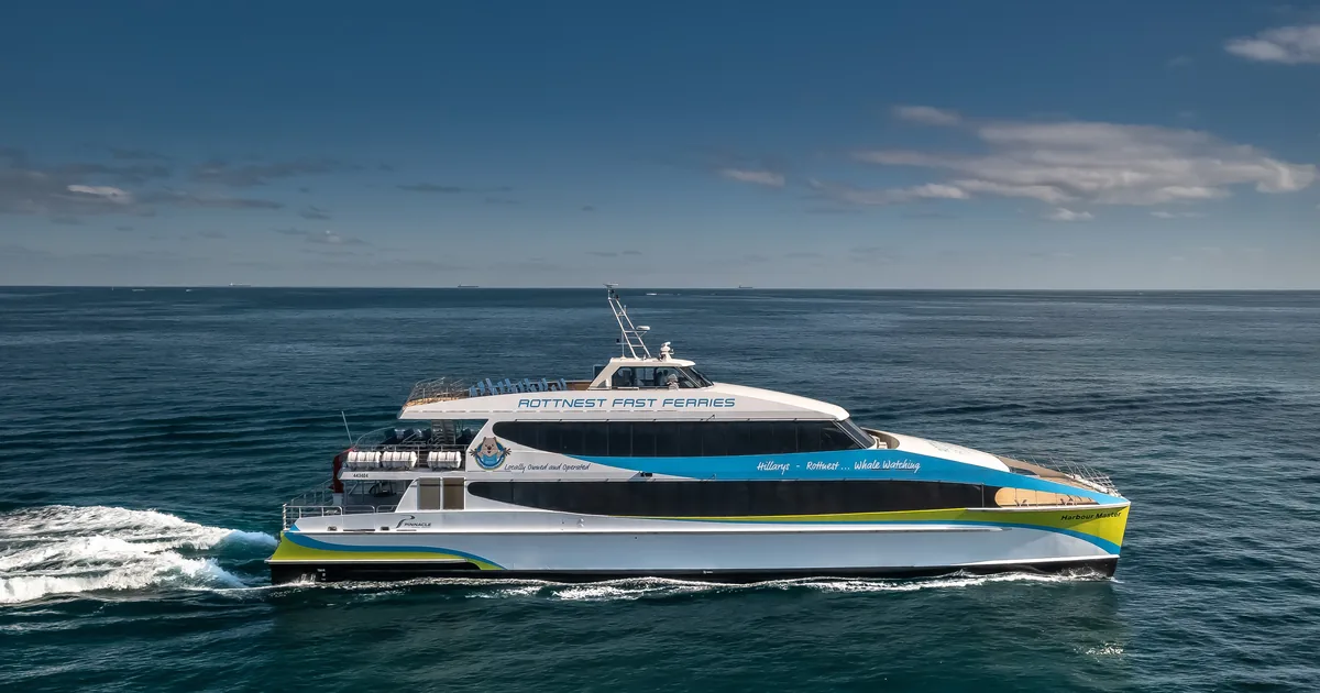 A white fast ferry crossing deep blue water toward Rottnest Island