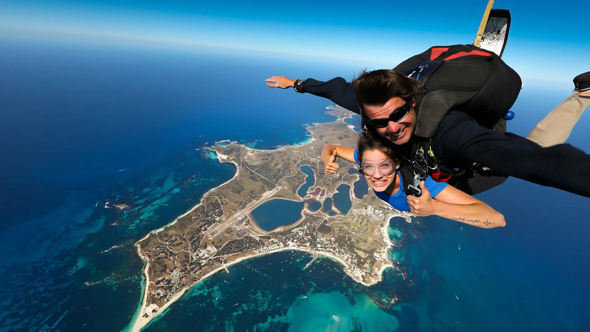 A tandem skydiver in freefall high above Rottnest Island and the blue Indian Ocean, from the tandem skydive listing