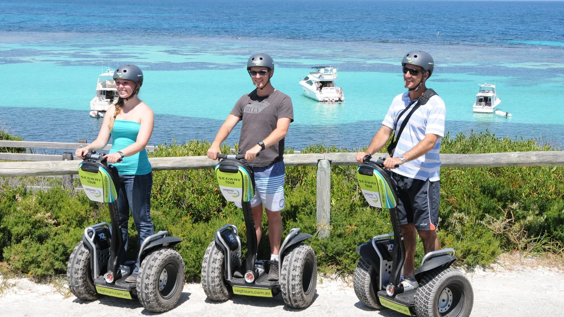 Three riders on Segways at a lookout above a turquoise bay on Rottnest Island, from the Segway fortress tour listing